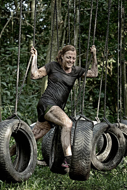 istock woman having fun during tire obstacle in forest 485995242