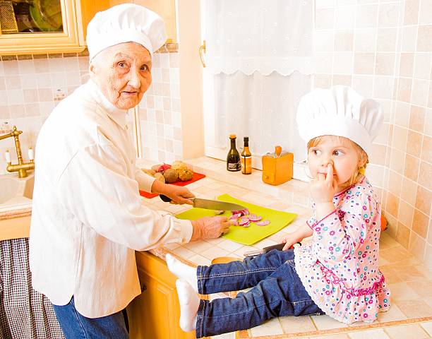 Grandmother cooking together with grand-daughter in the kitchen.