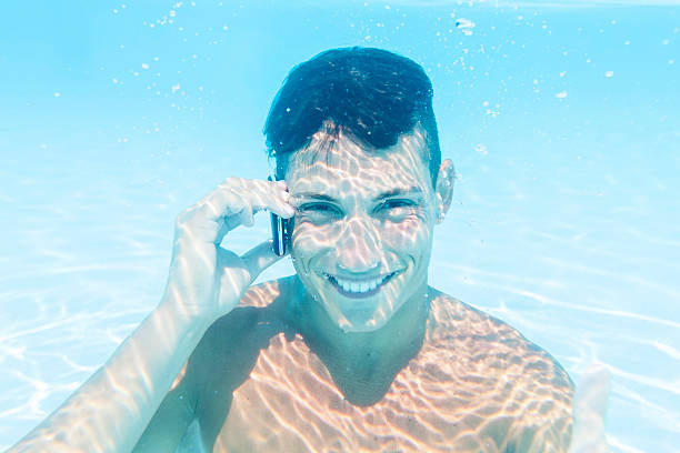 istock young man takes a call to smartphone underwater 485998272