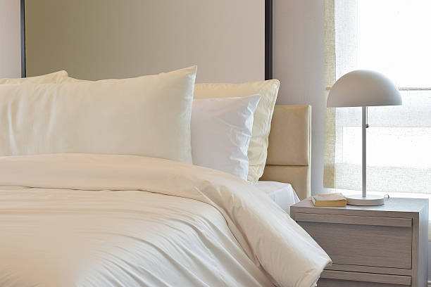 istock Cozy bedroom with pillows and reading lamp on bedside table 486001096