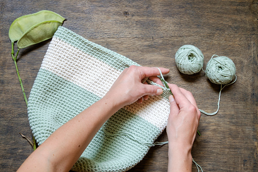 hand knitting crochet bag of green on a wooden table