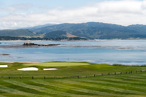 Monterey, California, USA - May 15, 2015: View at the green at the 18th hole at Pebble Beach Golf Course along side the Pacific Ocean, during a summer day. Pebble Beach Golf Course is one of the nations most well known.