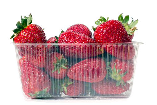 Strawberries in plastic container on a white background