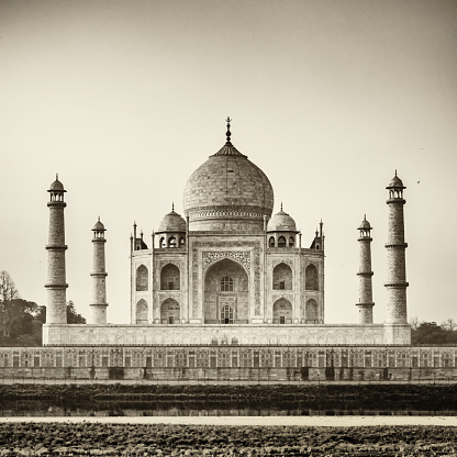 Famous Taj Mahal, the mausoleum located in Agra, India. It is one of the most recognizable structures in the world and is regarded as one of the eight wonders of the world. Black and White, Sepia toned image. Agra, India.