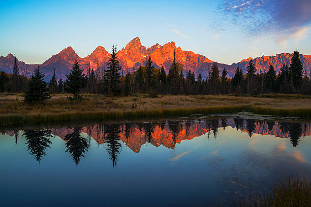 First light illuminating Tetons mountain range Beautiful reflection of Grand Teton mountain range in Snake River waters on a fine autumn morning as viewed from Schwabachers Landing in Grand Teton National Park, Wyoming, USA. I created this beautiful image in fall of 2013 teton range photos stock pictures, royalty-free photos & images