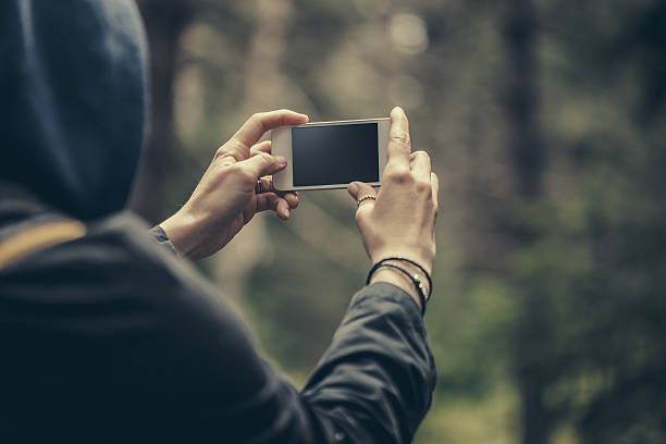 Traveler making selfie on a smart phone in the forest. Stock photo.
