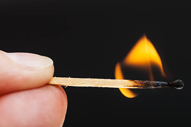 istock fingers with burning wooden match 486011630