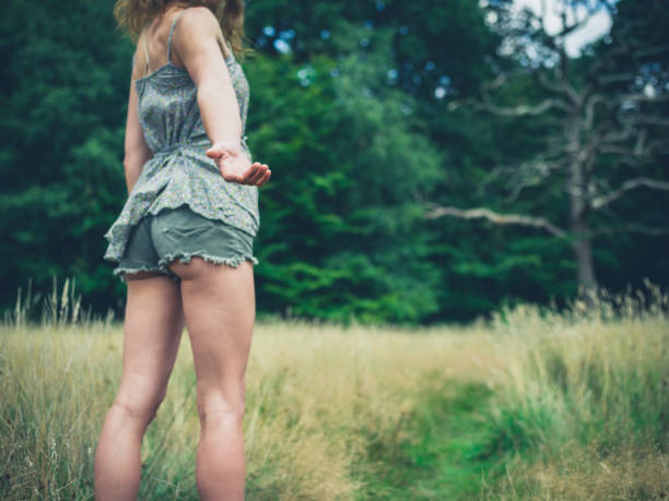 istock Young woman standing in meadow offering hand 486014756