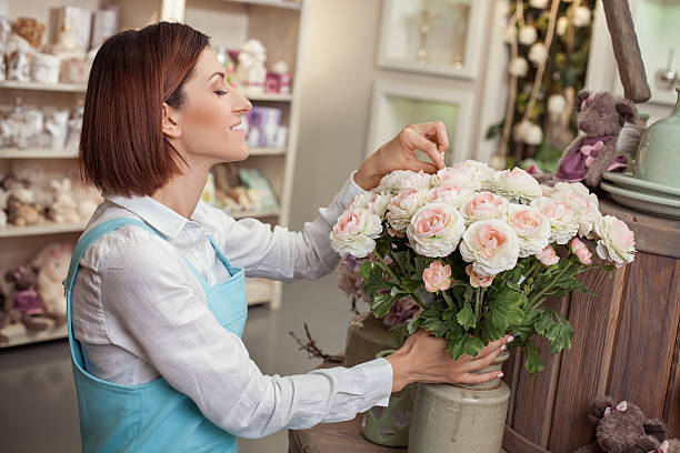 istock Beautiful young florist is working in her store 486017040
