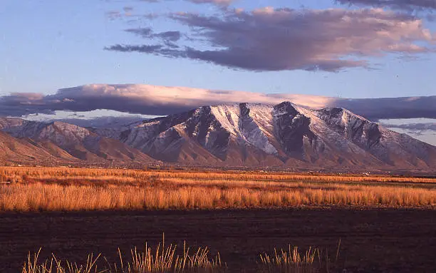 Grasslands and Wetlands along Utah Lake looking toward Spanish Fork Peak at dusk with cloud cap over Wasatch Mountains