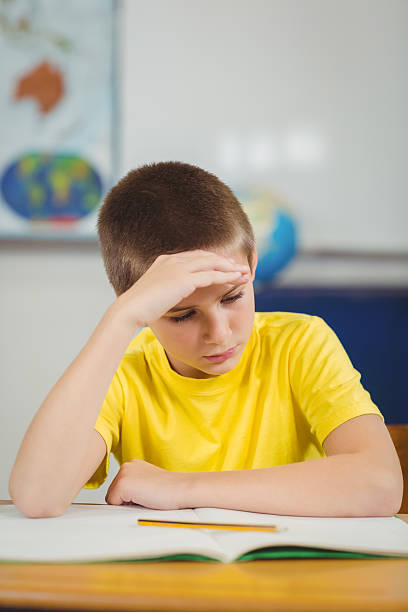 istock Concentrated pupil working at his desk in a classroom 486021580