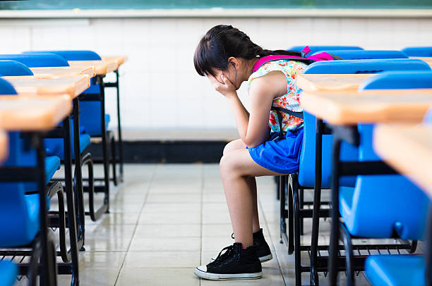 triste chica sesión y pensar en el aula - cuenca fotografías e imágenes de stock