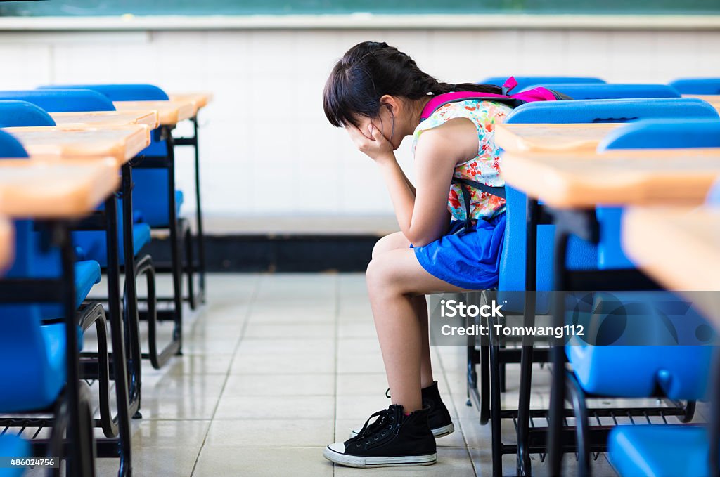 sad girl sitting and  thinking in the classroom Child Stock Photo