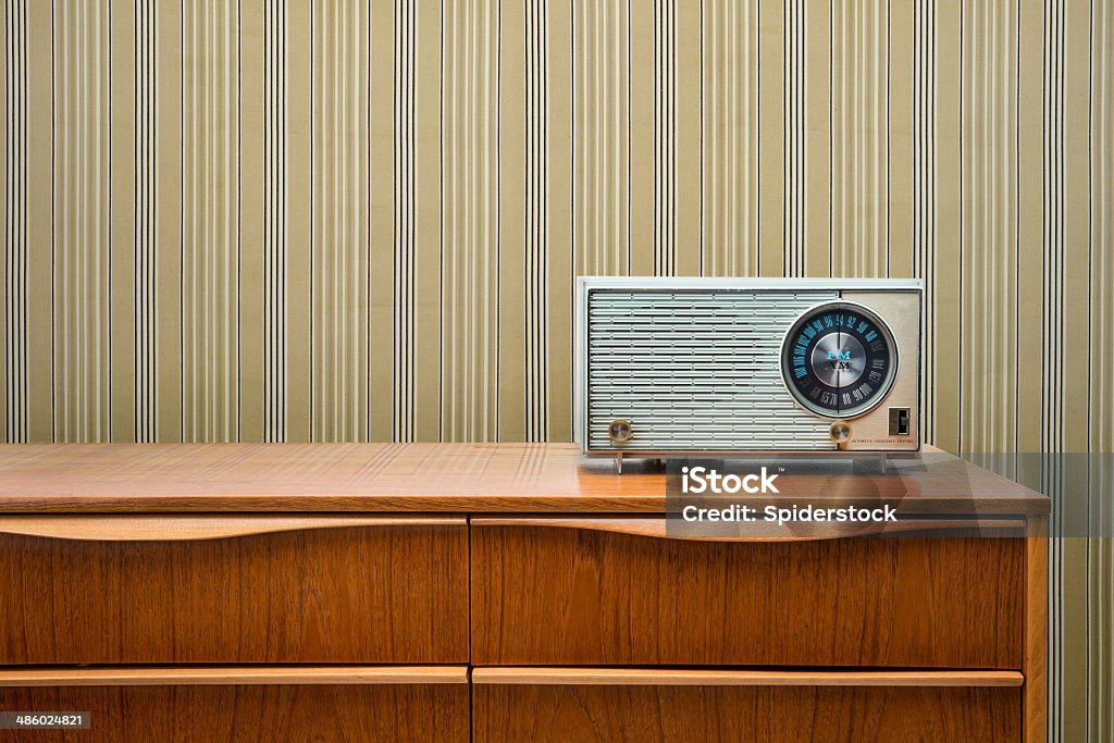 Vintage Radio On Dresser Blue vintage radio from the 1950's sitting on a mid-century modern dresser with striped wallpaper. Radio Stock Photo