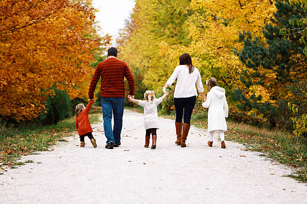 istock Family Walking Through Trees in Autumn 486024882
