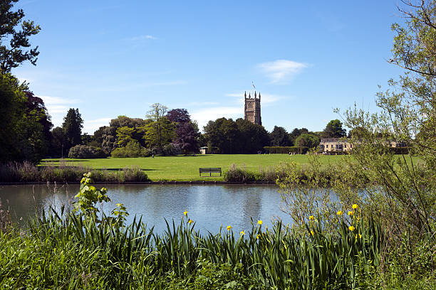 Picturesque Cotswolds, Cirencester church and park Tower of the landmark Abbey Church seen across Abbey Grounds in spring sunshine, Cirencester, The Cotswolds, Gloucestershire, UK gloucestershire stock pictures, royalty-free photos & images