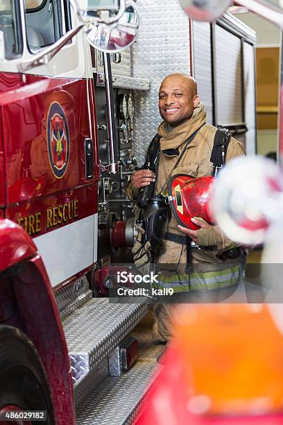 African American Fire Fighter Standing Next To Truck Stock Photo - Download Image Now