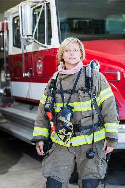 istock Female firefighter standing in front of fire truck 486032902