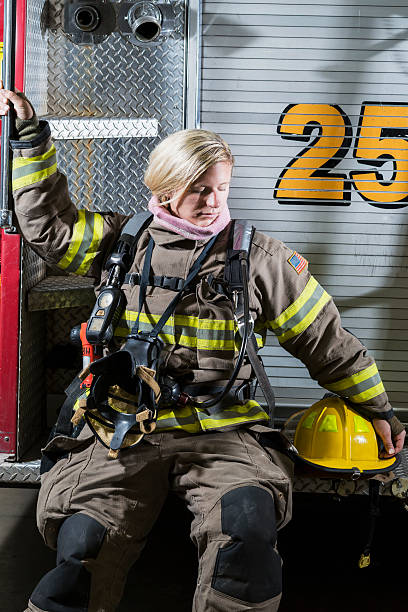 istock Female firefighter sitting on fire rescue truck 486032908