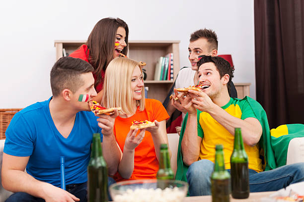 istock Multinational people eating pizza during the break in football match 486034445