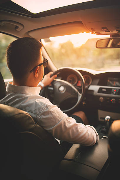 Driving Young man driving his car. driving steering wheel stock pictures, royalty-free photos & images