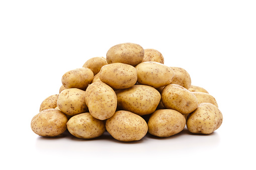 Big pile of raw organic potatoes is isolated on white background.