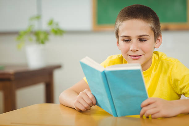 istock Smiling pupil reading book in a classroom 486038446