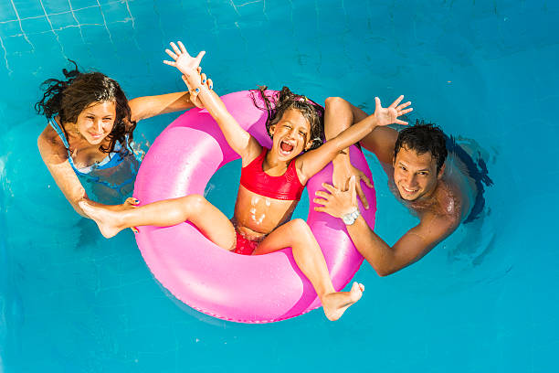 ご家族でのバケーション - men child swimming pool women ストックフォトと画像