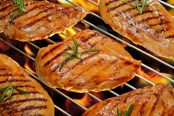 Grilled chicken Grilled chicken breast on the flaming grill. grilled chicken breast stock pictures, royalty-free photos & images