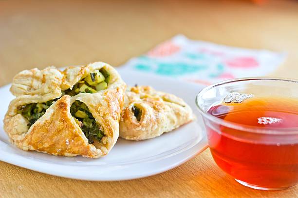 Fresh baked homemade puff pastry cakes with cup of tea