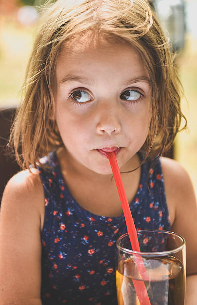 istock Girl drinking apple juice with a straw 486051138