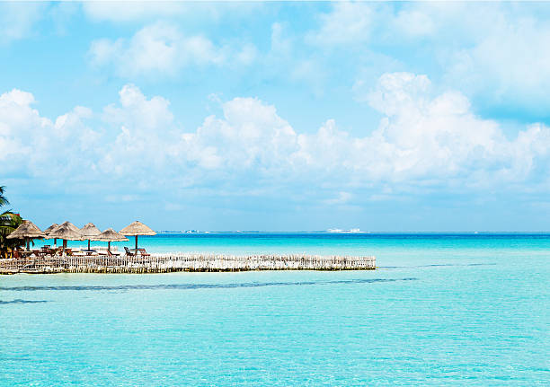 Playa Del Norte on Isla Mujeres Across from Cancun Mexico Subject: Horizontal view of the vacation resort hotel on the island of Isla Mujeres, with pristine white sandy beach that face the gentle waves of the aqua blue Caribbean Sea in the glow of morning sunlight.  isla mujeres stock pictures, royalty-free photos & images