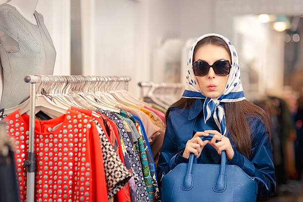 curioso ragazza in blu trench e occhiali da sole shopping - surprise women humor old fashioned foto e immagini stock