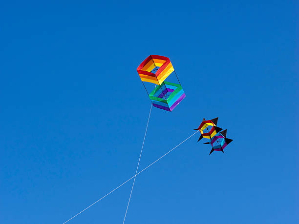 Long Beach, Washington, USA - August 19, 2015: 2 Kites Flying at the Washington State International Kite Festival held on August 17-23, 2015. This event is at Long Beach, Washington. These kites are above the beach, next to the ocean. The 2 kites are of a different size and design, with their white strings making a X against the bright sky.