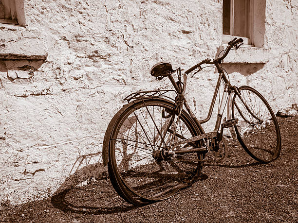 istock Rusty old bicycle leaning against wall in sepia 486054756