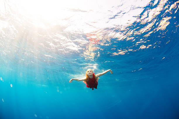 istock girl swimming underwater 486054967
