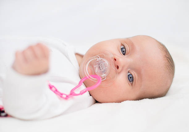 istock Newborn little baby with dummy on the bed. 486055402
