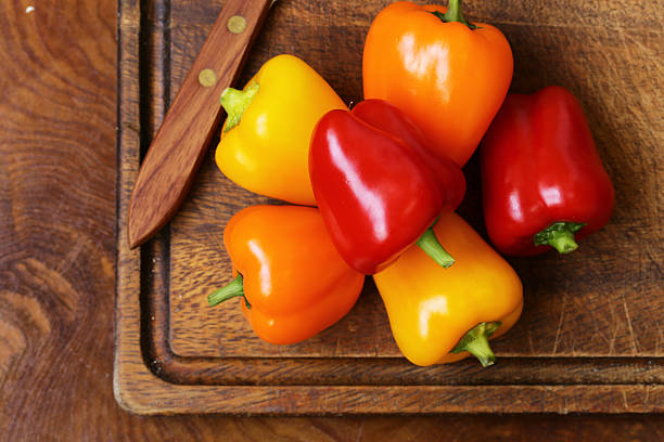 istock Fresh organic bell peppers on a wooden board 486055618
