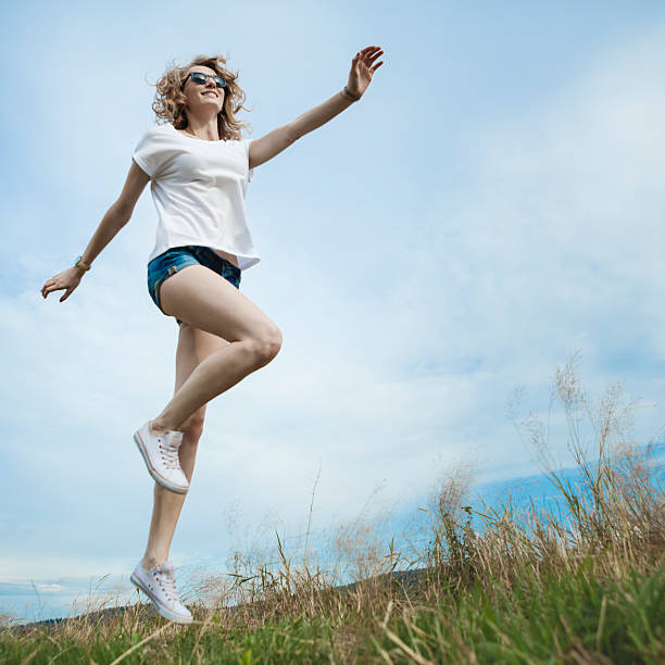 istock Happy woman jumping on meadow. 486058628
