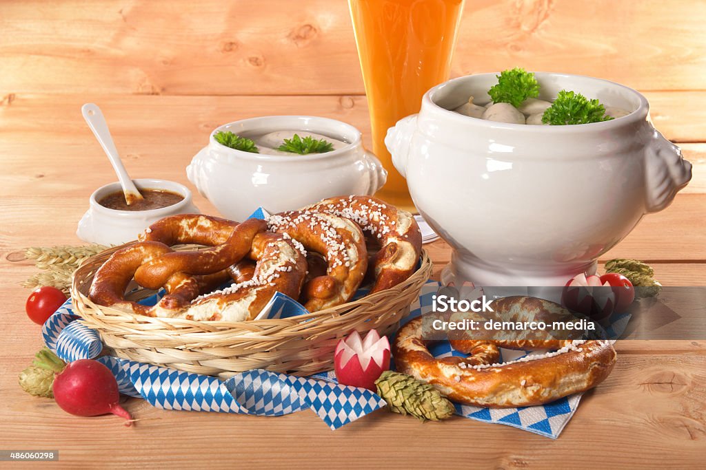 Bavarian veal sausage breakfast Bavarian veal sausage breakfast with sausages, soft pretzel, weissbier and mild mustard on wooden board from Germany 2015 Stock Photo