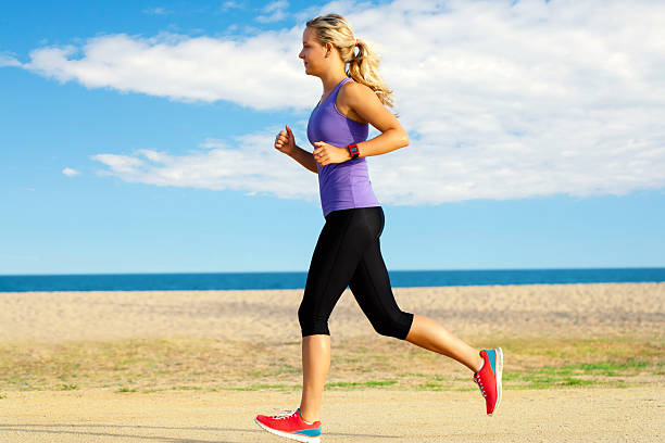 istock Young woman jogging along beach. 486060546