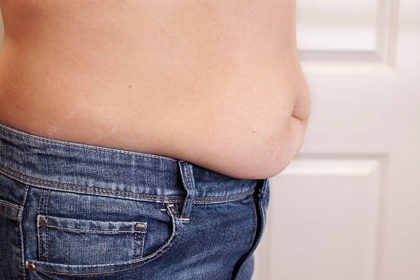 barriga de mulher com excesso de peso em jeans penduradas. - abdomen too small jeans overweight - fotografias e filmes do acervo