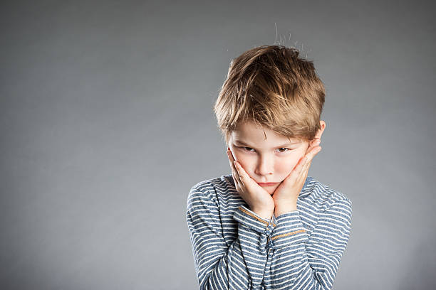 istock Portrait of boy, emotion, pouting, grey background 486067278