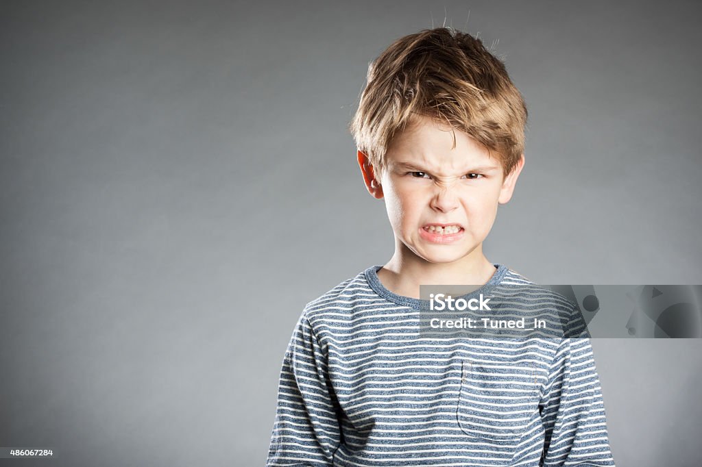 Portrait of boy, emotion, angry, grey background Child Stock Photo