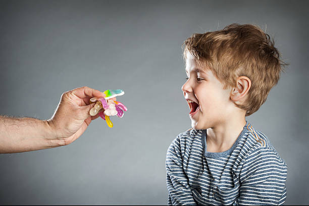 istock Portrait of boy, like sweets, grey background 486067292