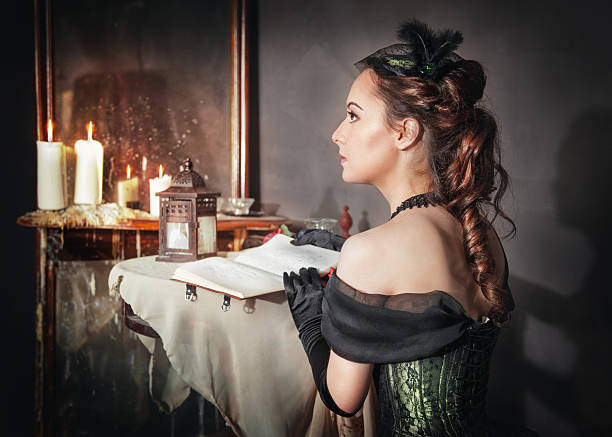 Beautiful woman in medieval dress near mirror Beautiful young woman in green medieval dress sitting near mirror mirror women baroque style fashion stock pictures, royalty-free photos & images