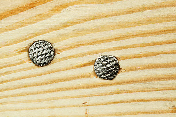 A messy pile of rusty nails and hammers on a wooden board