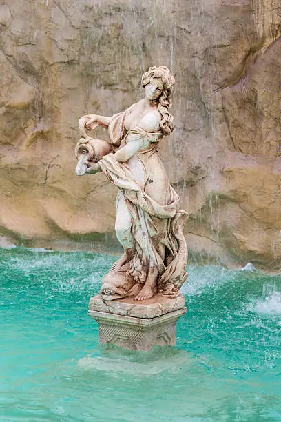 a beautiful fountain with statues and rocks