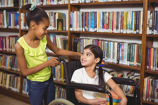 istock Smiling pupil in wheelchair holding books 486073838