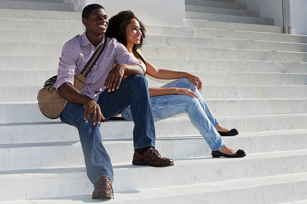Teenage couple sitting at steps at school